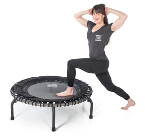 Lady with arms behind her head stepping up onto a fitness trampoline to exercise