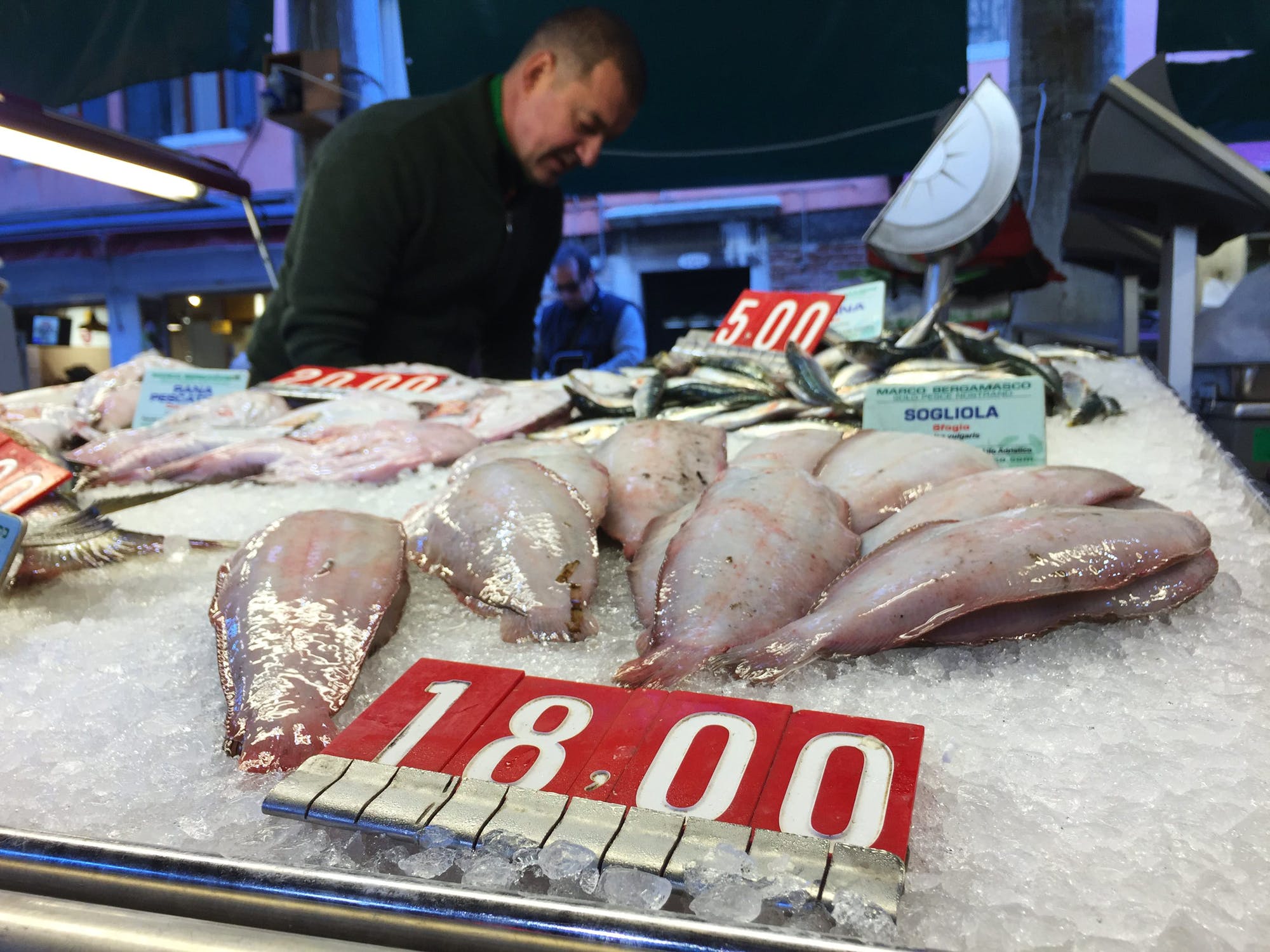 Fresh raw fish over ice at stall in a seafood market.